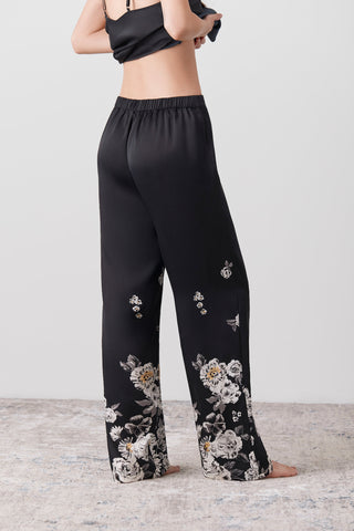 Back side of a woman wearing long silk pants printed by hand