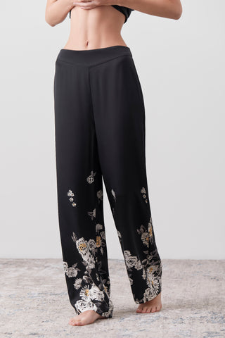 Woman wearing a pair of Silk pants printed by hand on a white background