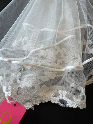 White lace veil with a pink tag on a black background