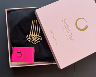 Shikkosa hair comb and card in a pink box on a dark surface