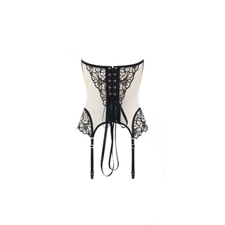 A cream-colored lace corset with black floral lace panels, a black lace-up front, and attached black garter straps with ties, shown against a plain white background.
