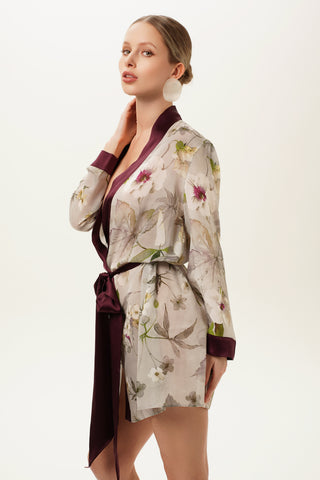 Side of a woman wearing a floral silk robe with a plain background