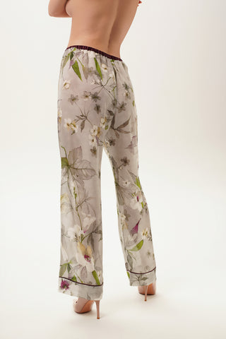 Floral-patterned pajama pants worn by a woman on a white background