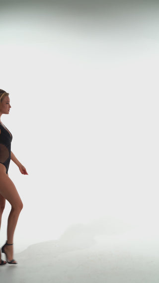 Woman cat walk wearing a bodysuit with a large peacock embroidery on the back