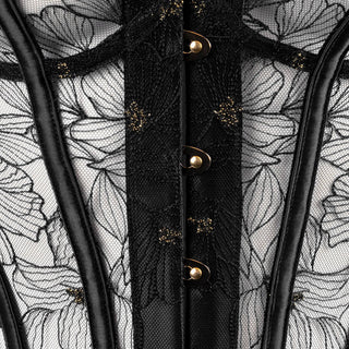 Close up of a black lace corset with floral patterns and gold buttons on a hanger.